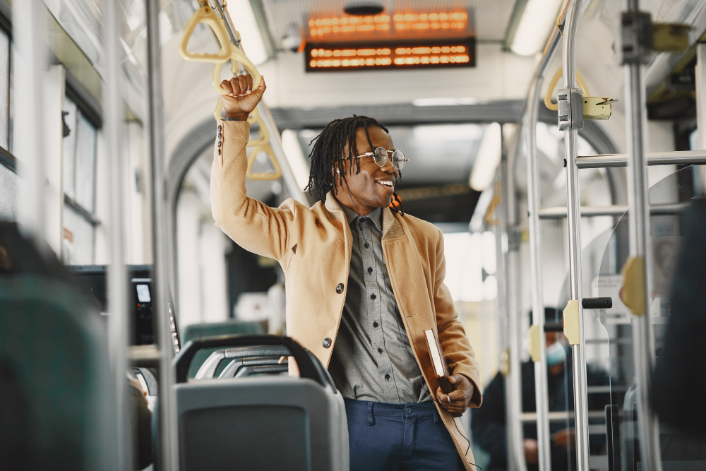 Choosing the Right Credit Card: American man riding in the city bus. Guy in a brown coat. Man with notebook. 