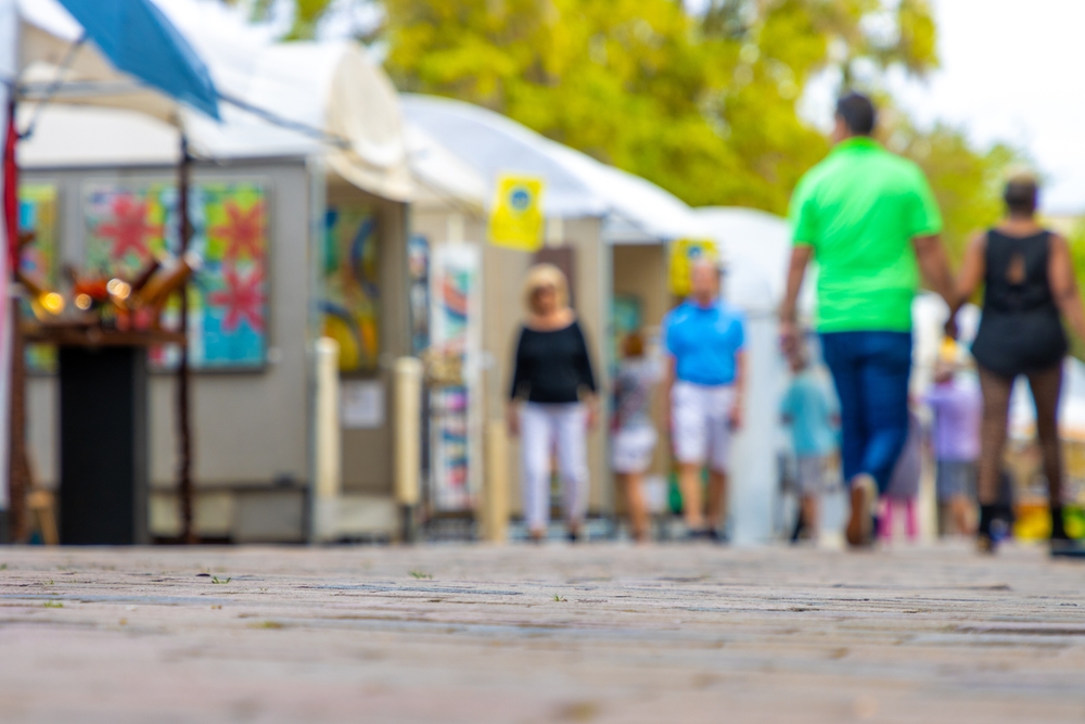 The Best Seasonal Festivals in Zadar and What They Tell Us About Croatian Culture: People walk around an art festival enjoying paintings and drawings in a downtown public park in this defocused photo. 