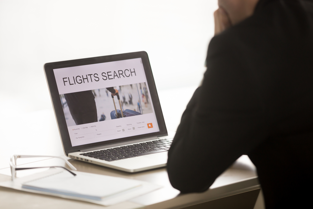 How to Score the Best Deals on Flights Every Time: Businessman using laptop for searching cheap low cost business flight, choosing airfare deal, comparing trip prices, booking airplane ticket online on web service 