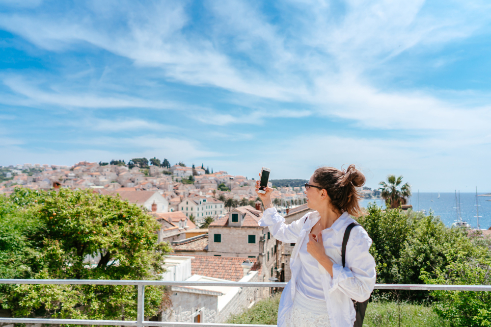 How to avoid tourist traps in Zadar: Young beautiful woman on a balcony overlooking a small town in Croatia