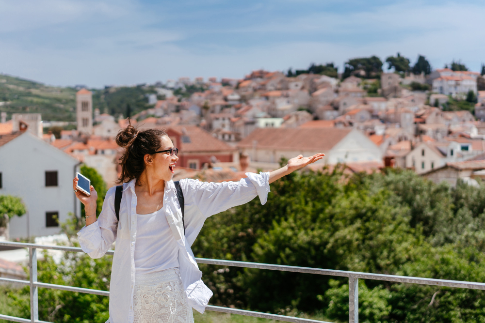 The Worst Times to Visit Zadar: Young beautiful woman on a balcony overlooking a small town in Croatia