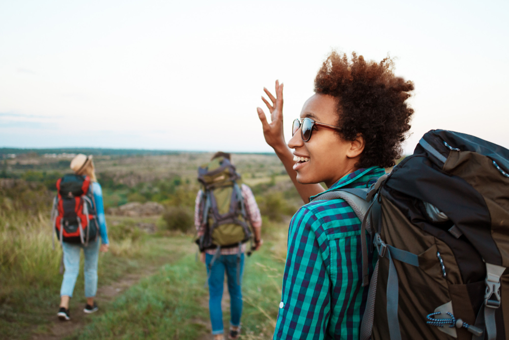 Creative Family Vacation Ideas That Go Beyond the Beach: Picture showing people on adventure and a beautiful woman with backpack smiling