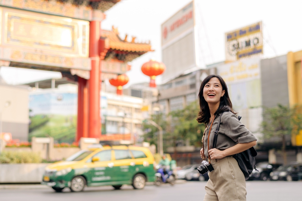 The Biggest Safety Mistakes People Make When Traveling Solo: photo of a young asian woman backpack traveler enjoying 