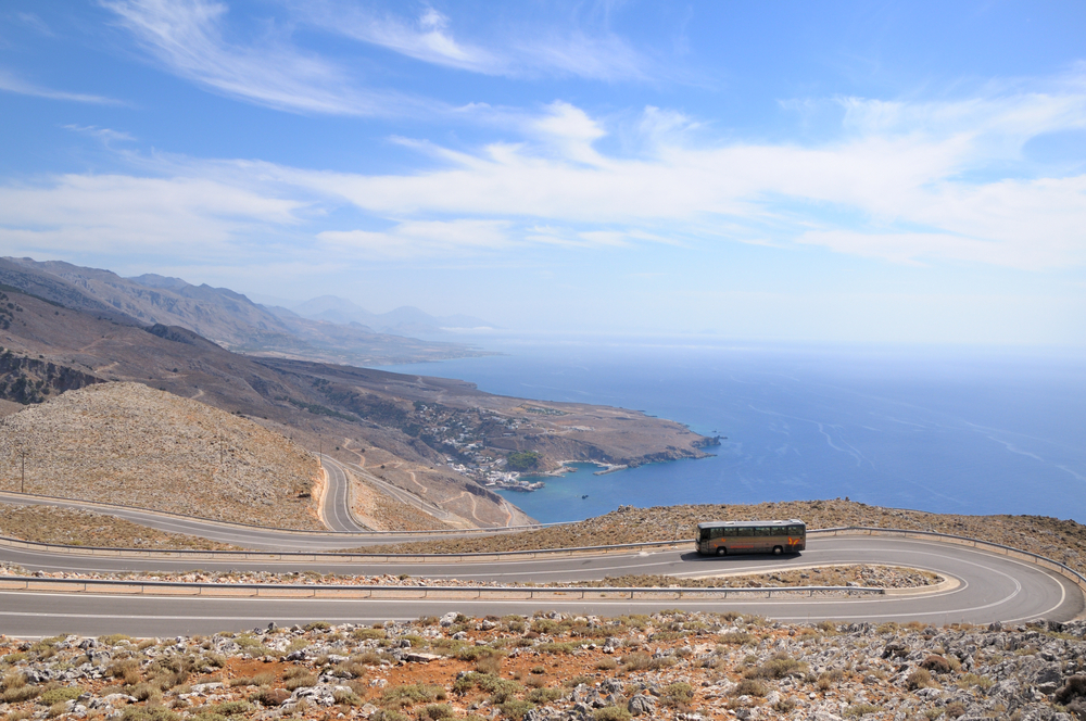 Eco-Friendly Tips for Tourists Visiting Greece: A bus is driving on the road. Blue sky with beautiful white clouds. 