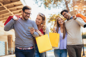 friends having fun shopping together holding